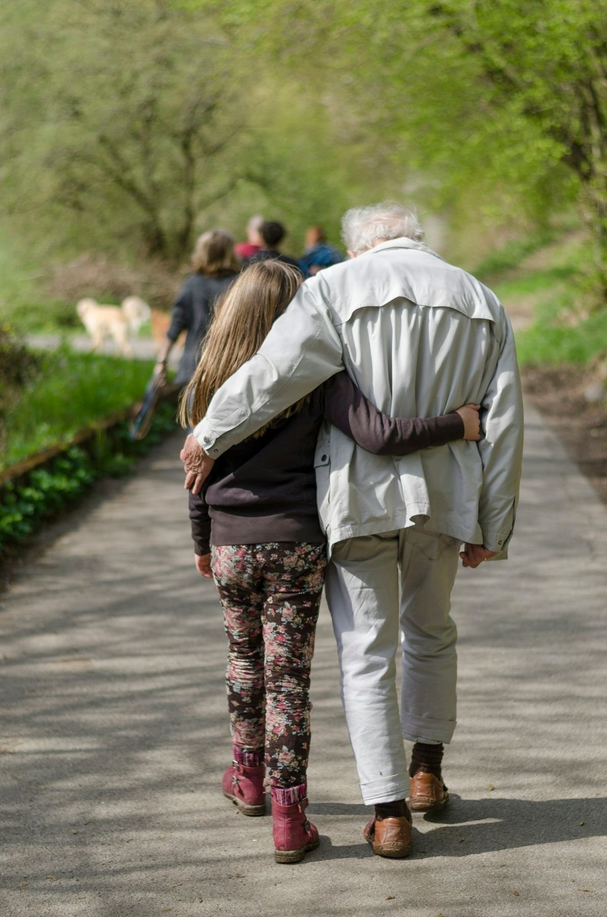 An adult and child walking together on a path